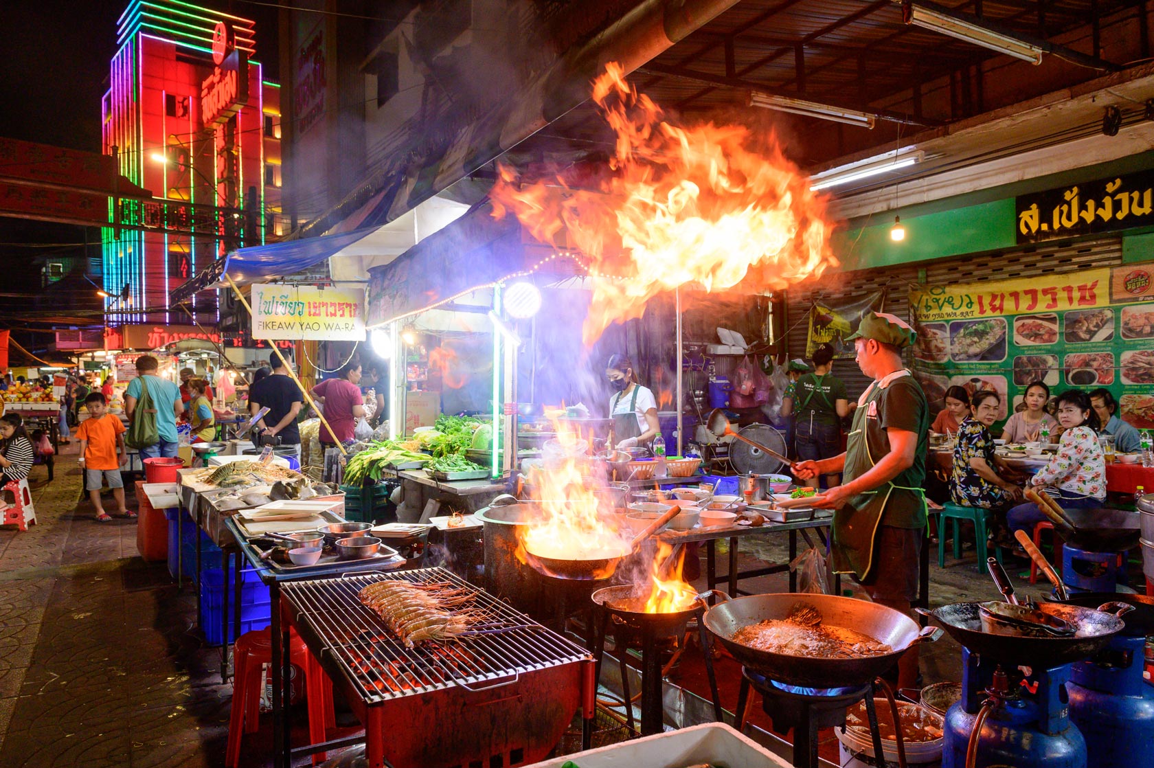 Chef cooking food at street side restaurant in Bangkok
