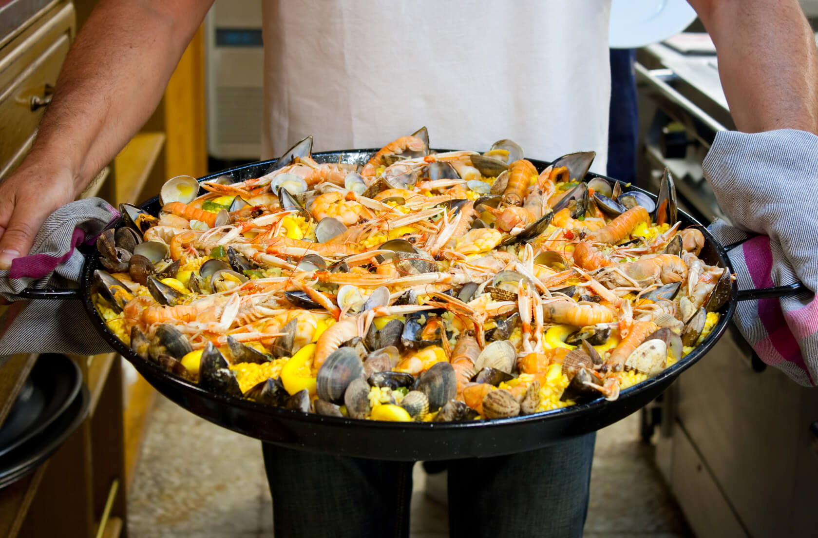 Carrying a freshly made seafood paella cooked in a basque gastronomic society in San Sebastian