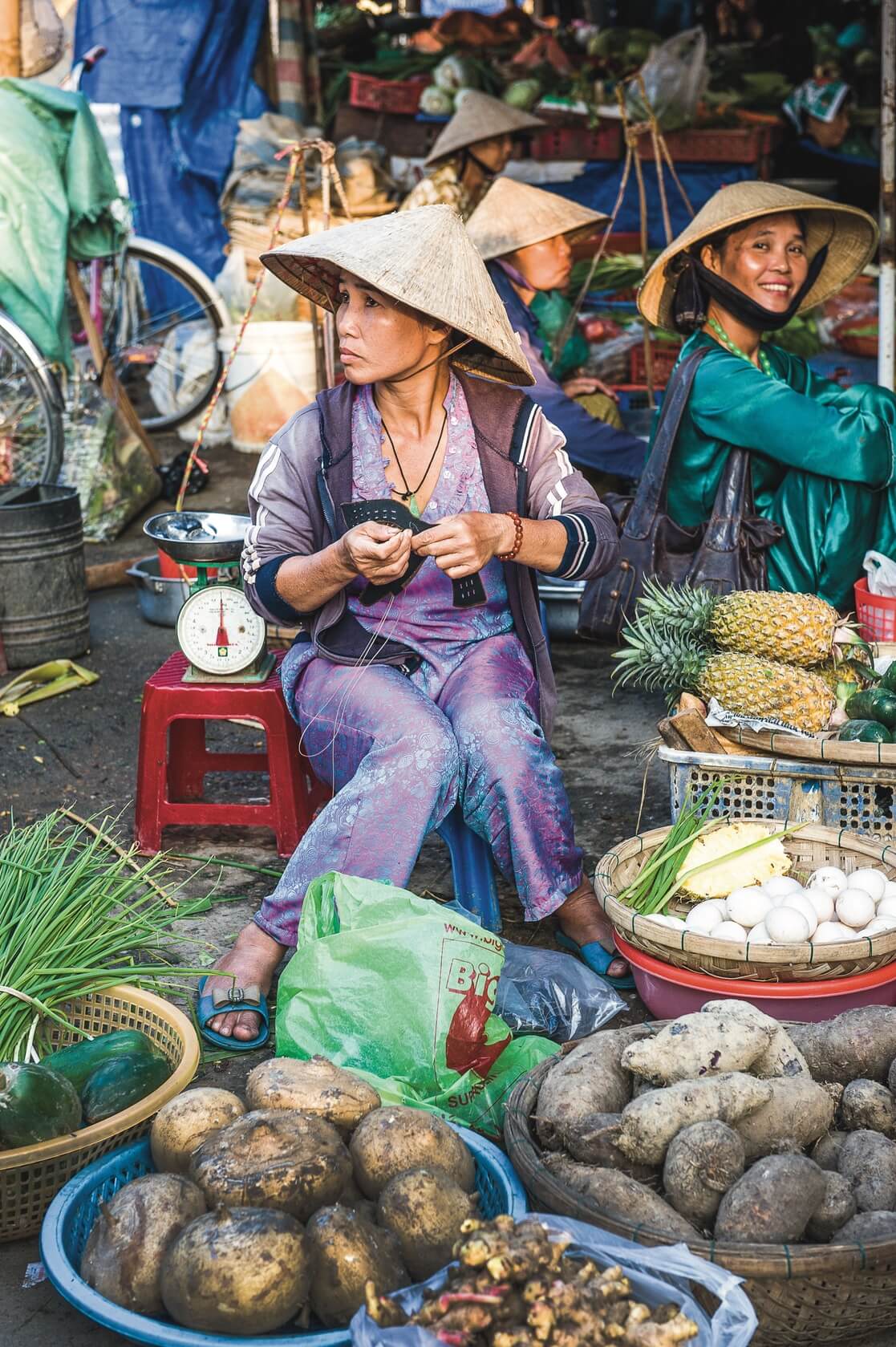 A woman sells vegetables at a market in Saigon