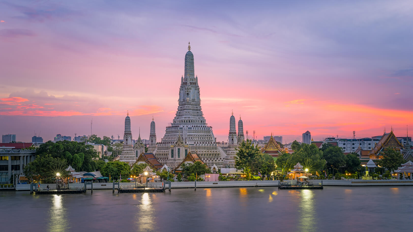 A waterside image of the Wat Arun in the sunset. 
