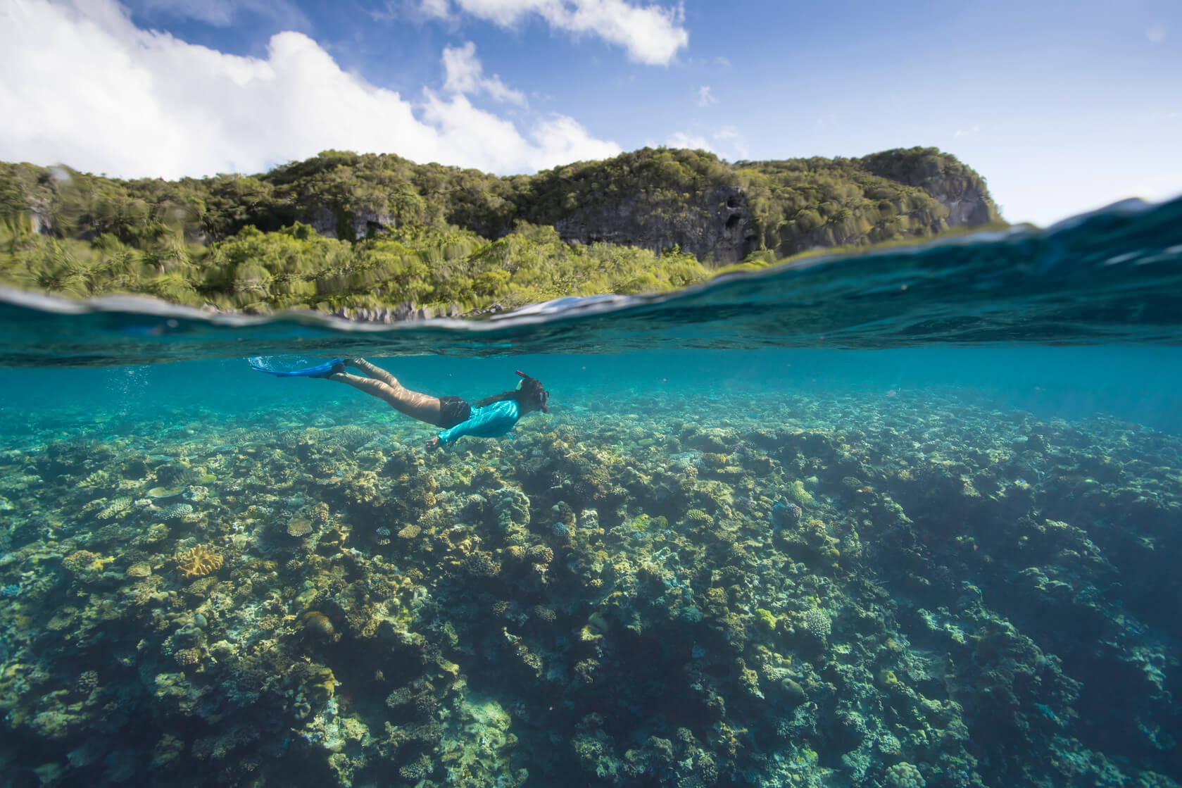 A woman snorkels in clear blue water
