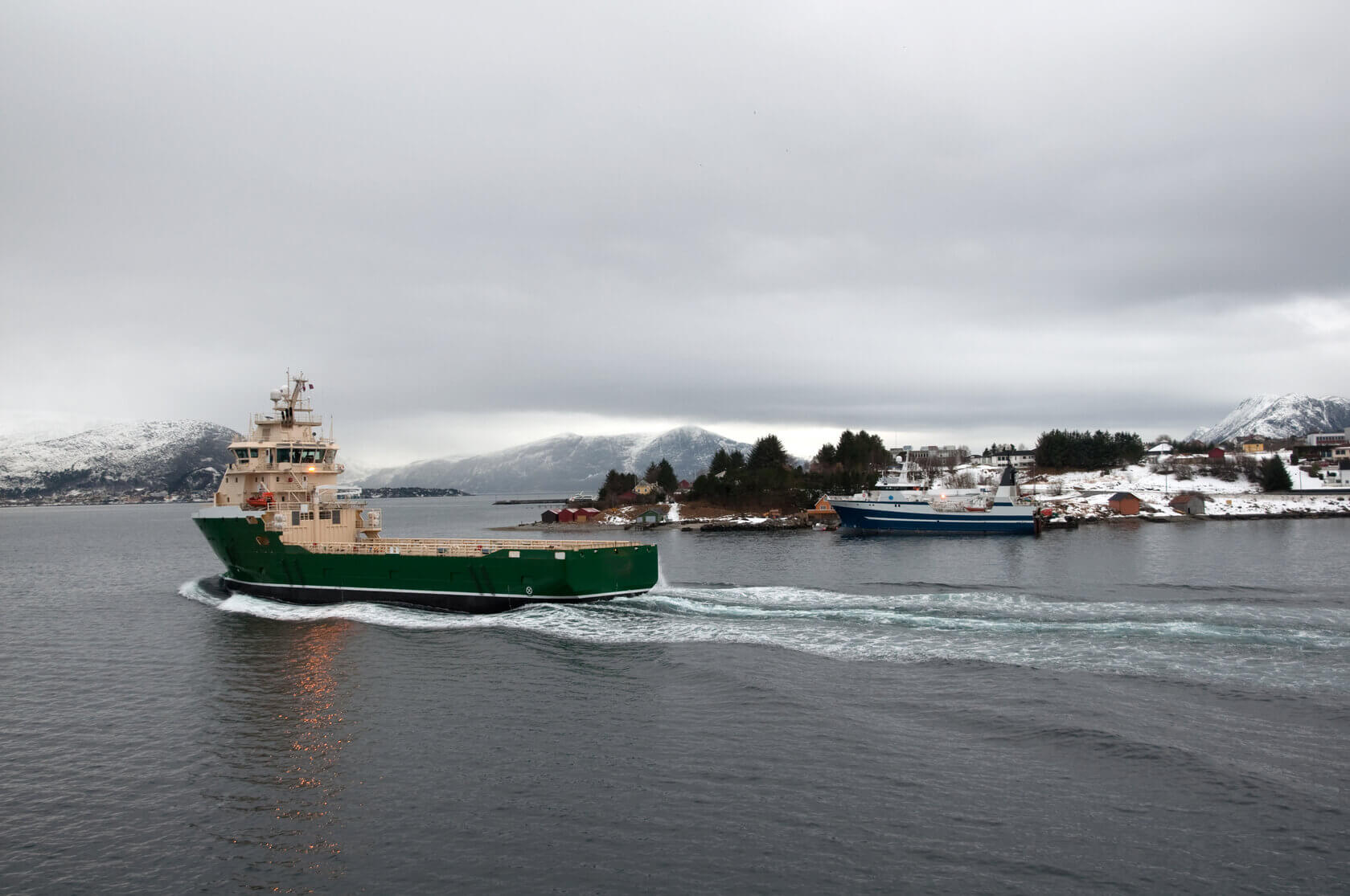 A fishing boat leaves the port at Alesund,  Norway