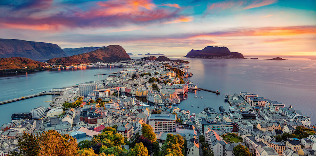 From the bird's eye view of Alesund port town on the west coast of Norway, at the entrance to the Geirangerfjord. Colorful summer sunset at the Nord port. Traveling concept background.